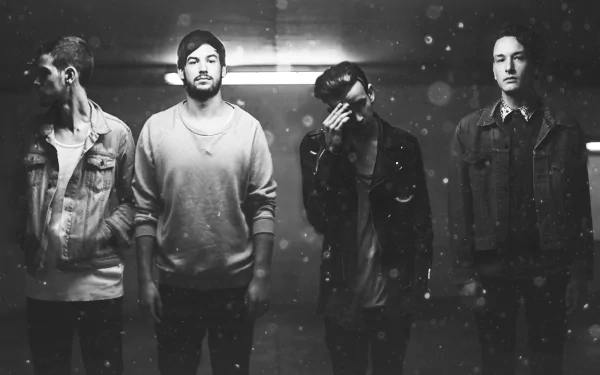 HD wallpaper featuring a monochrome shot of The 1975 band members standing in a dimly lit setting with a dusty atmosphere.