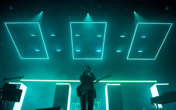 HD desktop wallpaper featuring The 1975 in concert with neon stage lighting.
