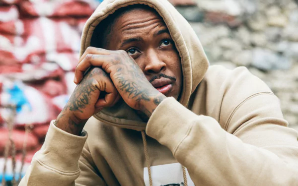 HD desktop wallpaper featuring a person with tattoos in a hoodie against a graffitied wall, tagged with YG.